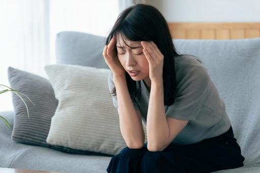 頭を押さえて悩む女性 頭を押さえて悩む女性 女性,悩む,困るの写真素材