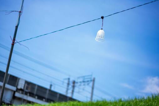 澄んだ青空と電線、白い籠の風景の写真