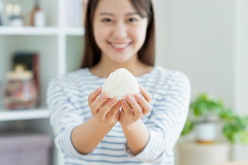 おにぎりを食べる若い女性 おにぎりを食べる若い女性 米,おにぎり,おむすびの写真素材