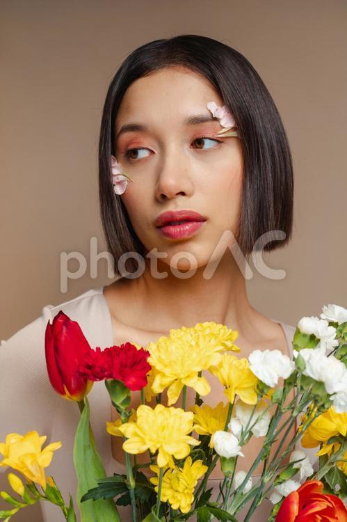 カラフルな花を持ち横を見る女性 女性,花束,カラフルの写真素材