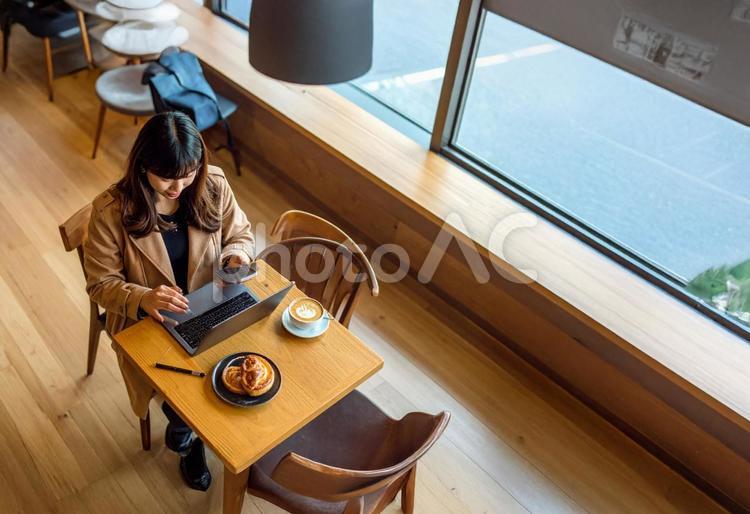 出張先のカフェで経費精算するビジネス女性 カフェ,pc,スマホの写真素材