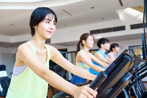 ジムでトレーニングする女性　複数 トレーニング,フィットネス,エアロバイクの写真素材