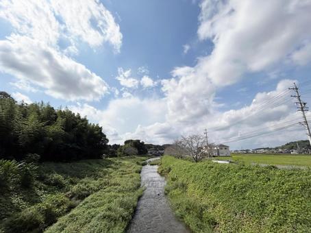 穏やかに流れる河川と白い雲が浮かぶ青空 空模様,空,雲の写真素材