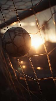 ゴールネットに突き刺さるサッカーボール ゴールネットに突き刺さるサッカーボールの写真