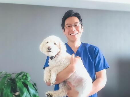 犬を抱える動物病院の男性スタッフ 男性,笑顔,犬の写真素材