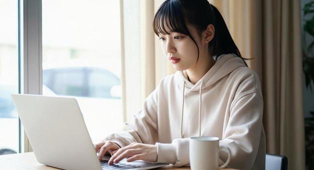 パソコンを打つ女性の写真