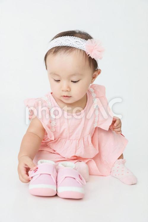ファーストシューズを触る赤ちゃん 赤ちゃん,ファーストシューズ,1歳の写真素材