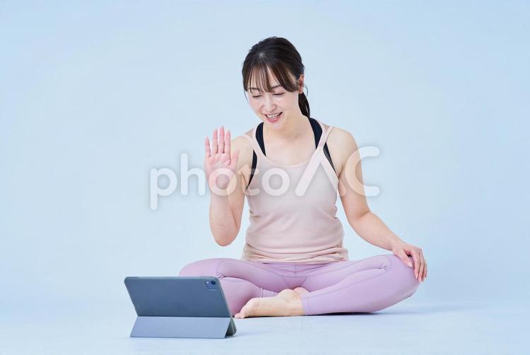 スポーツウェア姿でPCの画面を見る女性 ヨガ,フィットネス,レッスンの写真素材