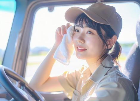 女性トラック運転手 休憩中 汗を拭くの写真