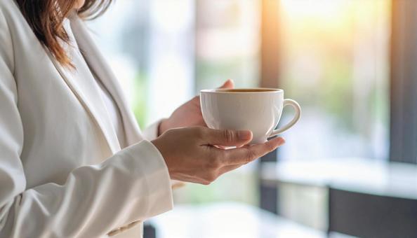 コーヒーカップを手にする女性の手 コーヒーカップを手にする女性の手の写真