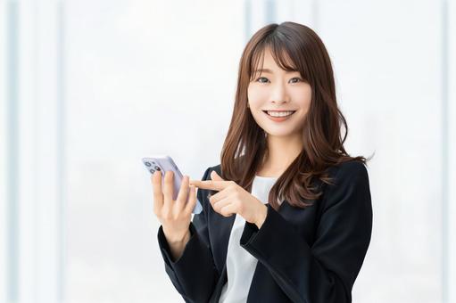 スマホを持つ笑顔の女性・ビジネスウーマン スマホを持つ笑顔の女性・ビジネスウーマン 女性,スマホ,スマートフォンの写真素材