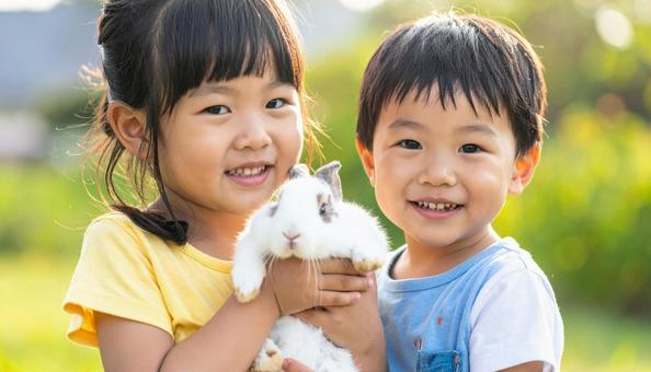 可愛いウサギを抱く兄妹の写真