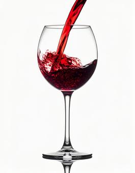 赤ワインを注がれているワイングラス 赤ワインを注がれているワイングラスの写真