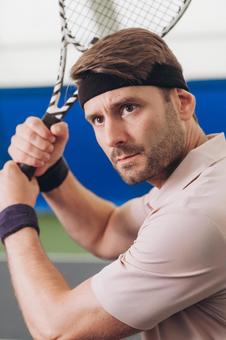 ラケットを両手で握りしめて真剣な目をしている男性 男性,外国人,テニスの写真素材