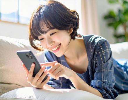 ソファでスマホを見る女性7 ソファでスマホを見る女性7の写真