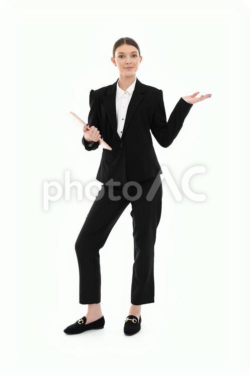 パソコンを持ちカメラ目線でポーズする女性 女性,ノートパソコン,持つの写真素材