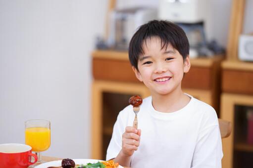 肉団子をフォークに刺し持つ男の子 男の子,肉団子,ミートボールの写真素材
