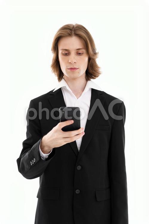 右手に持つスマホを見る外国人男性 男性,スマートフォン,持つの写真素材