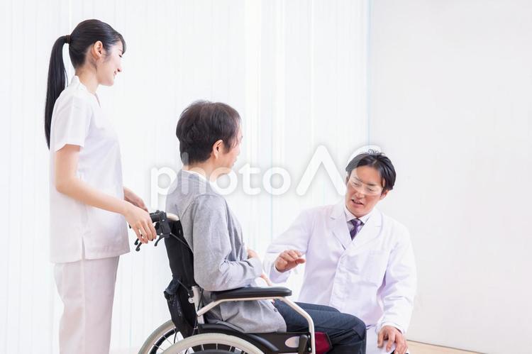 車椅子に乗る患者と医者（話す） 医者,介護士,車椅子の写真素材