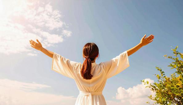 空に向かって手を伸ばす女性 空に向かって手を伸ばす女性の写真