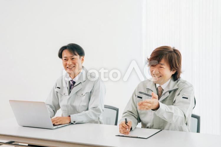会議室にいる作業着をきたビジネスマン（質問） エンジニア,作業服,作業員の写真素材