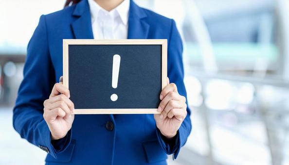 注意  「!」マークを持つ女性の手 注意  「!」マークを持つ女性の手の写真