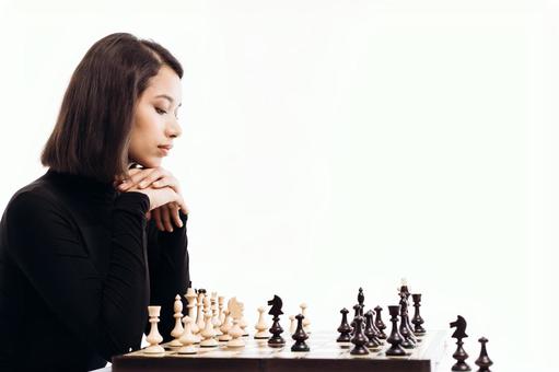 チェスをしている横向きの黒いタートルネックの女性(白背景) チェスをしている横向きの黒いタートルネックの女性(白背景) チェス,女性,20代の写真素材