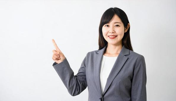 指差して案内するスーツ姿の女性 指差して案内するスーツ姿の女性の写真