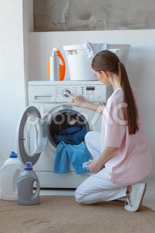 しゃがんで洗濯をする女性の後ろ姿 女性,人物,洗濯物の写真素材