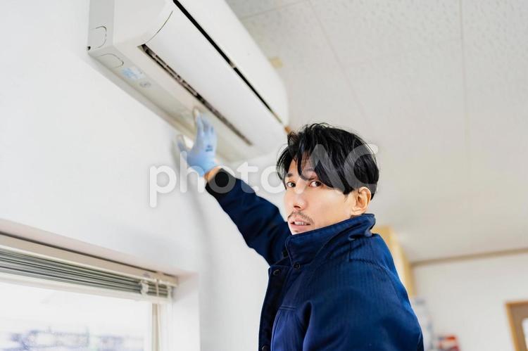 エアコンの取り付けにきた電気工事作業員 ビジネス,ビジネスマン,男の写真素材