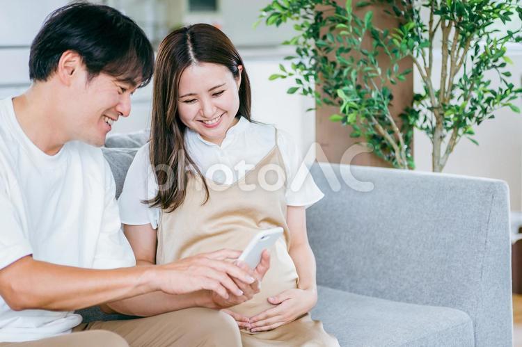 スマホを見る妊婦と男性 妊婦,妊娠,夫婦の写真素材
