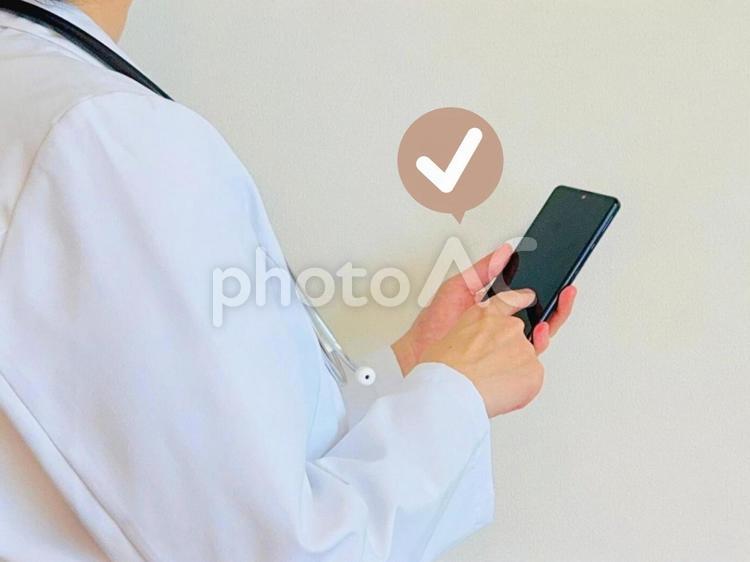 スマホを操作する白衣を着た人 スマホ,女性,チェックの写真素材