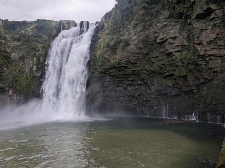 激しく落ちる雄川の滝と岩肌から染み出る水 激しく落ちる雄川の滝と岩肌から染み出る水 雄川の滝,瀑布,荒々しいの写真素材