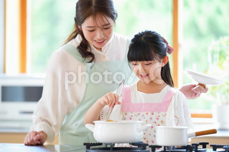 カレーを混ぜる女の子と母 母,娘,女の子の写真素材