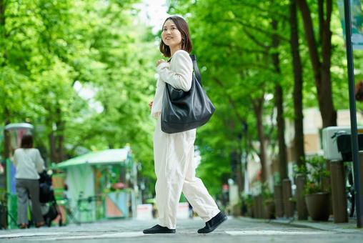 緑のある街並みを歩く女性 緑のある街並みを歩く女性 女性,外出,通勤の写真素材