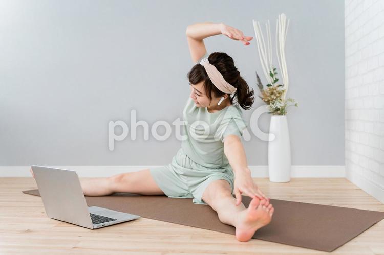 家でストレッチをするおしゃれな日本人女性 ストレッチ,前屈,ヨガの写真素材
