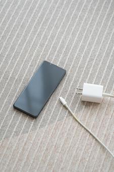 カーペットの上にスマホと充電コード カーペットの上にスマホと充電コード スマホ,部屋,手の写真素材
