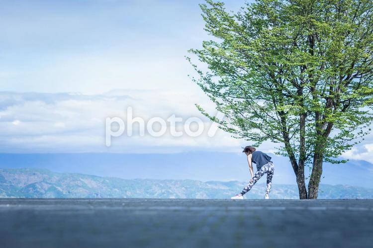 絶景とスポーツウェアの女性（屈伸） 準備運動,背景,ウォーミングアップの写真素材
