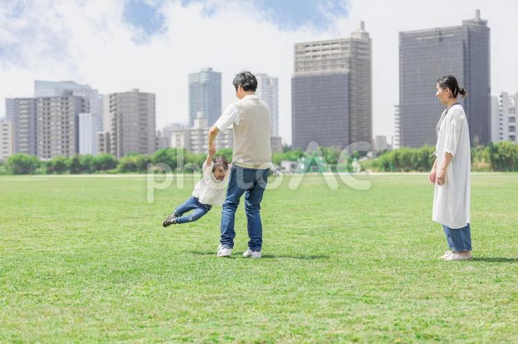 手を繋いでグルグルをして遊ぶ親子 ファミリー,家族,人物の写真素材