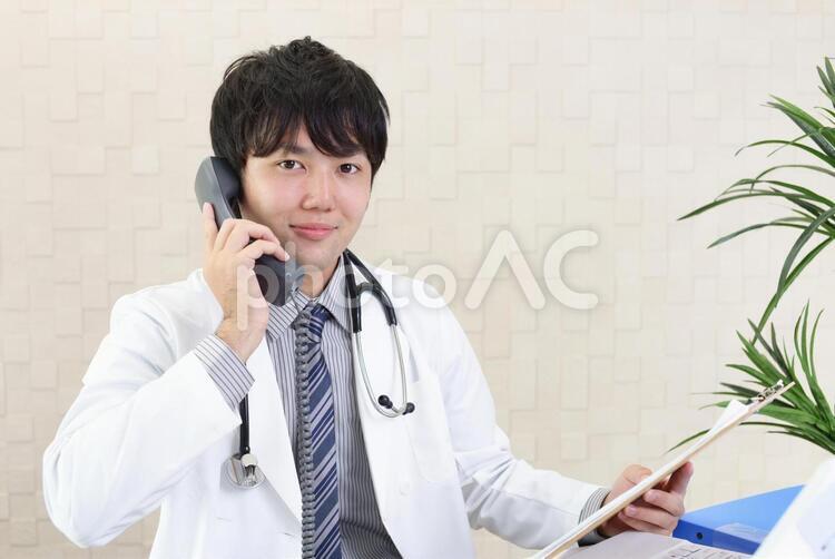受話器を持つ笑顔の医師 男性,医師,医者の写真素材