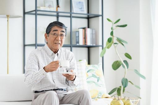 リビングでコーヒーを飲むシニアの男性 リビングでコーヒーを飲むシニアの男性 シニア,コーヒー,男性の写真素材