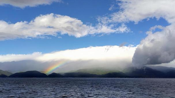 洋上の水面に映る虹と雄大な自然 虹,レインボー,海の写真素材