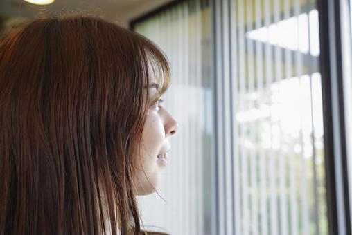 窓の外を見つめる女性の横顔 窓の外を見つめる女性の横顔 女性,横顔,笑顔の写真素材