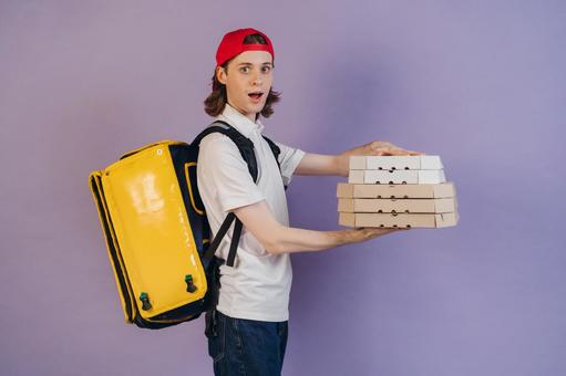 ピザを配達する男性（紫背景）の写真