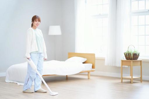 片手で掃除機を持ち微笑む女性 女性,掃除機,掃除の写真素材