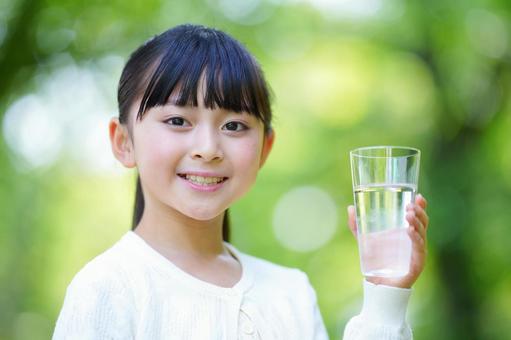 公園でグラスに入った水を見せる女の子 子ども,女の子,小学生の写真素材