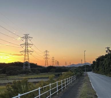 鉄塔送電線と夕焼け田舎道 たそがれ,自然,風景の写真素材