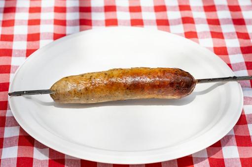 紙皿に置かれた串焼きのソーセージ ソーセージ,串,キャンプの写真素材