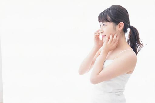 フェイシャルケアをする若い女性 フェイシャルケアをする若い女性 若い,洗面台,白背景の写真素材