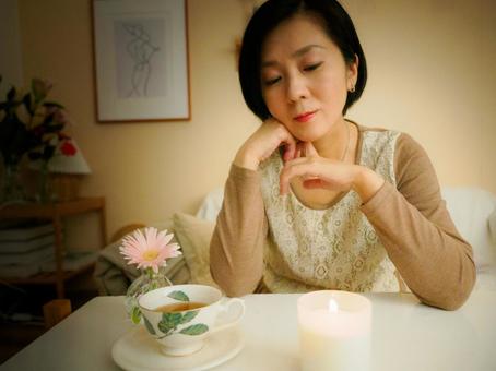 36:キャンドルを眺めてお茶を楽しむ女性 36:キャンドルを眺めてお茶を楽しむ女性 キャンドル,お茶,リラックスの写真素材